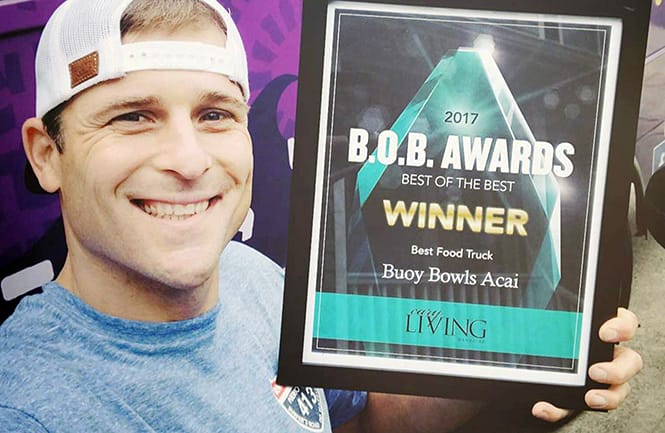Derek Sharpe holding 2017 B.O.B. Awards for Cary Magazine