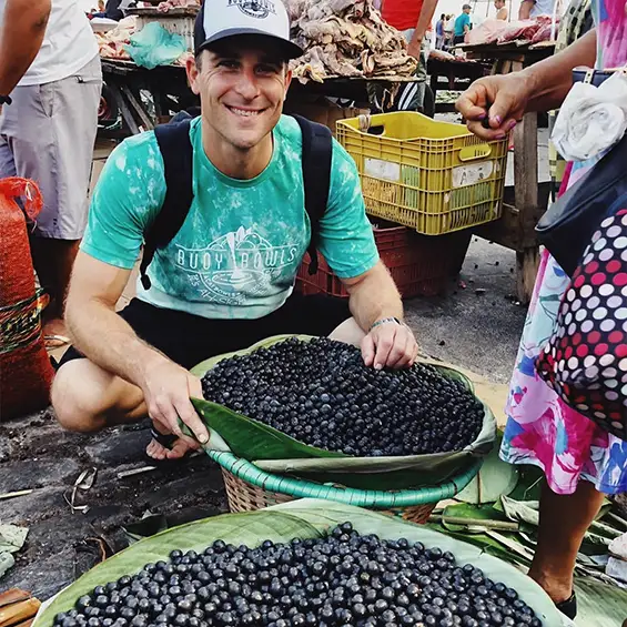 Buoy Bowls founder Derek Sharpe harvesting açaí berries in Brazil.
